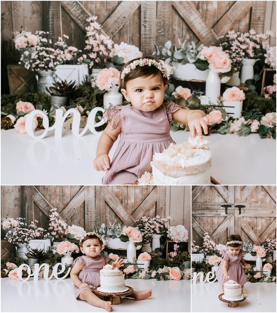 baby girl smiling at the camera picking at her cake during his cake smash photo sesion