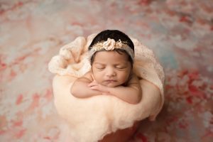 Newborn Posed In A Peach-Colored Container For Affordable Newborn Photography