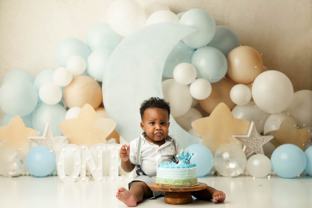 Cake Smash Theme Ideas For Your Baby'S First Birthday 14 Dallas Moon And Stars Cake Smash Photography Featuring A Baby Boy With A Blue Birthday Cake, Crescent Moon Backdrop, Balloon Garland, And Celestial First Birthday Theme.