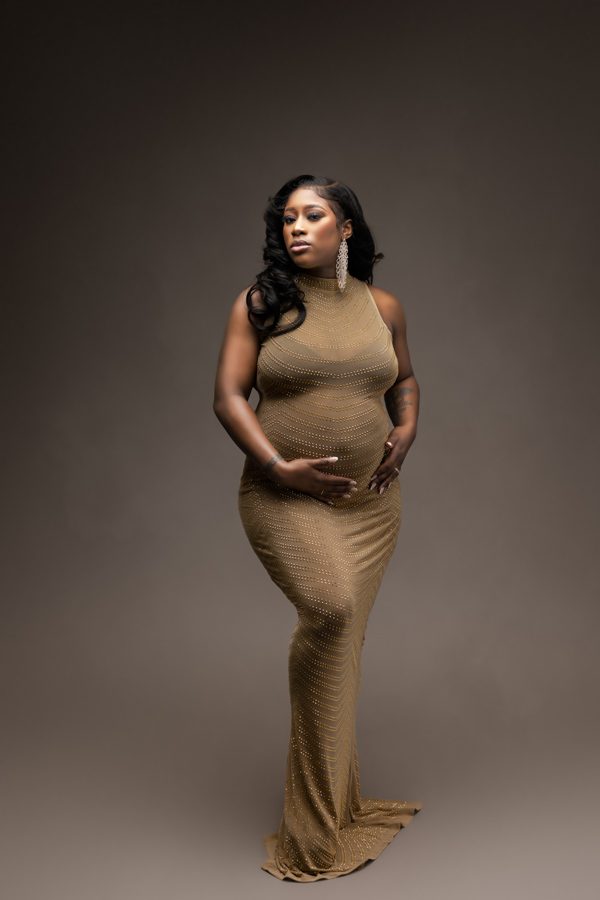 beautiful pregnant woman cradling baby bump for studio maternity photo