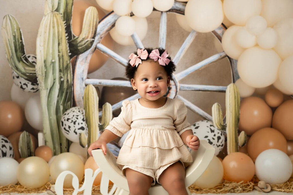 6 Dos And Don'Ts For A Successful Cake Smash Photo Session 12 Western Cake Smash Photography Dallas Featuring A Rustic First Birthday Setup With Wagon Wheel Backdrop And Balloon Garland.