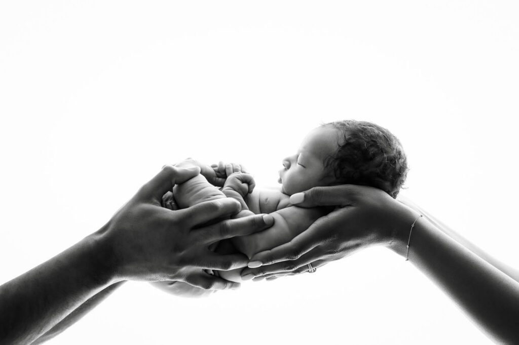 Black &Amp; White Newborn Photography In Dallas 22 Newborn Cradled Safely In Both Parents' Hands During A Fine Art Newborn Photography Session In Dallas