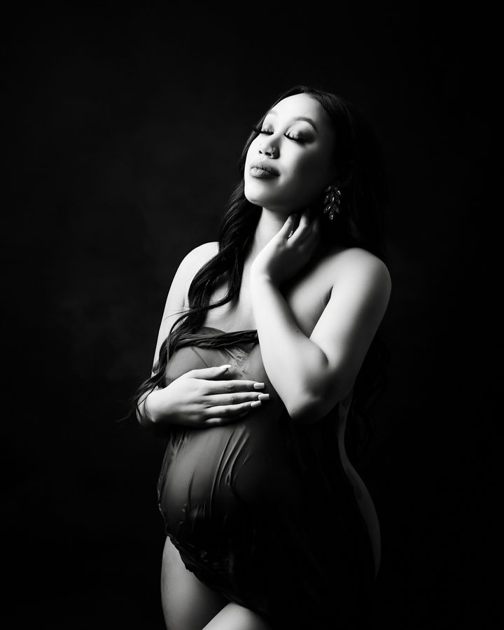 pregnant women posed holding belly black and white maternity photo