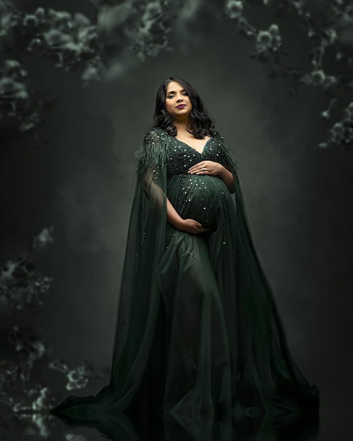 maternity pose woman wearing green gown looking at camera