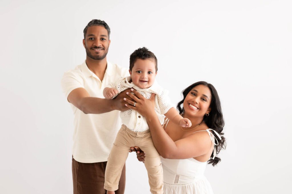Why Include Siblings In Your Cake Smash Session? 22 Parents Holding Their One-Year-Old During A Family First Birthday Portrait Session In Dallas.