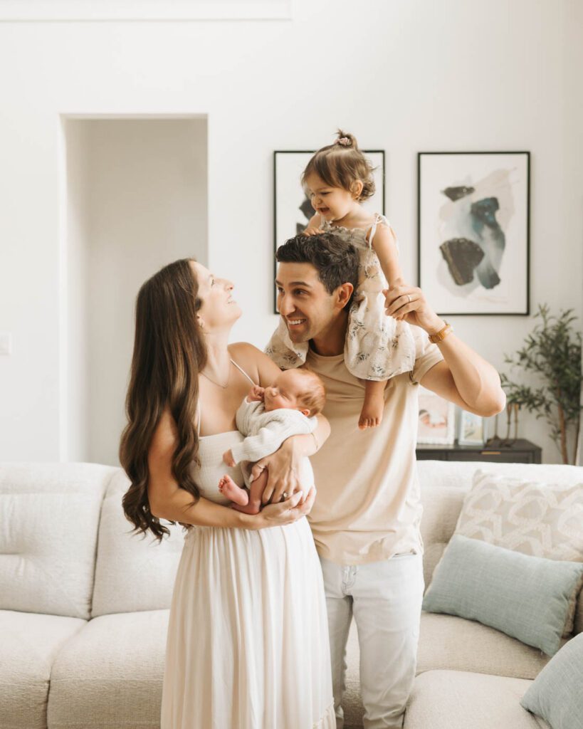 Postpartum Newborn Photography: Supporting New Parents Through A Calm, Thoughtful Experience 12 Parents Holding Their Newborn And Toddler During A Lifestyle Newborn Photography Session In Dallas.