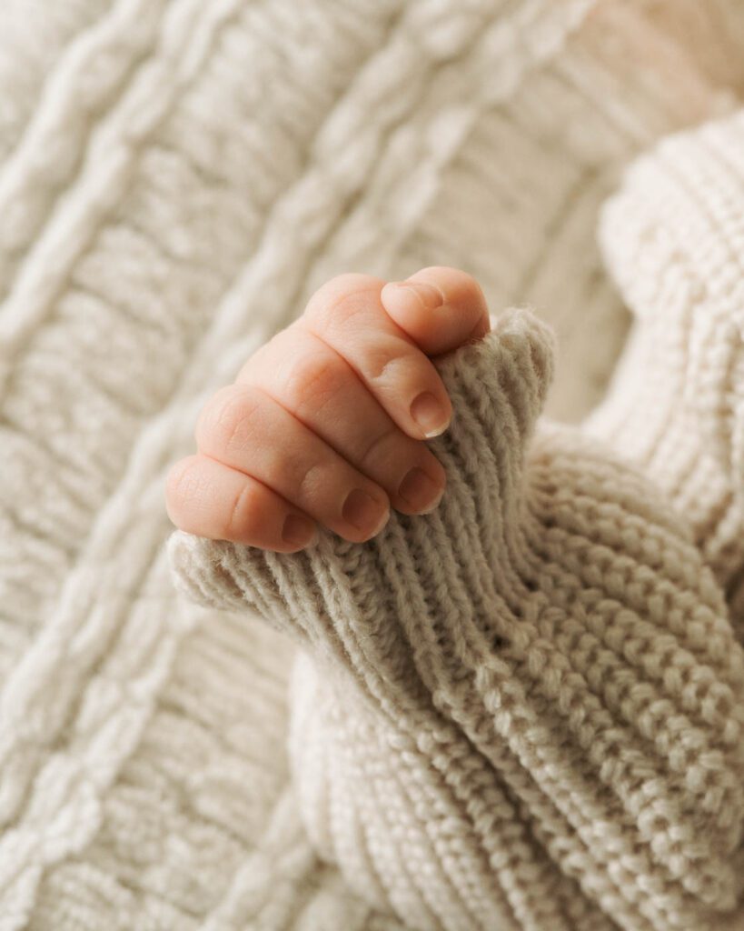 Postpartum Newborn Photography: Supporting New Parents Through A Calm, Thoughtful Experience 15 Close-Up Photograph Of A Newborn'S Tiny Hand During A Professional Newborn Photography Session.