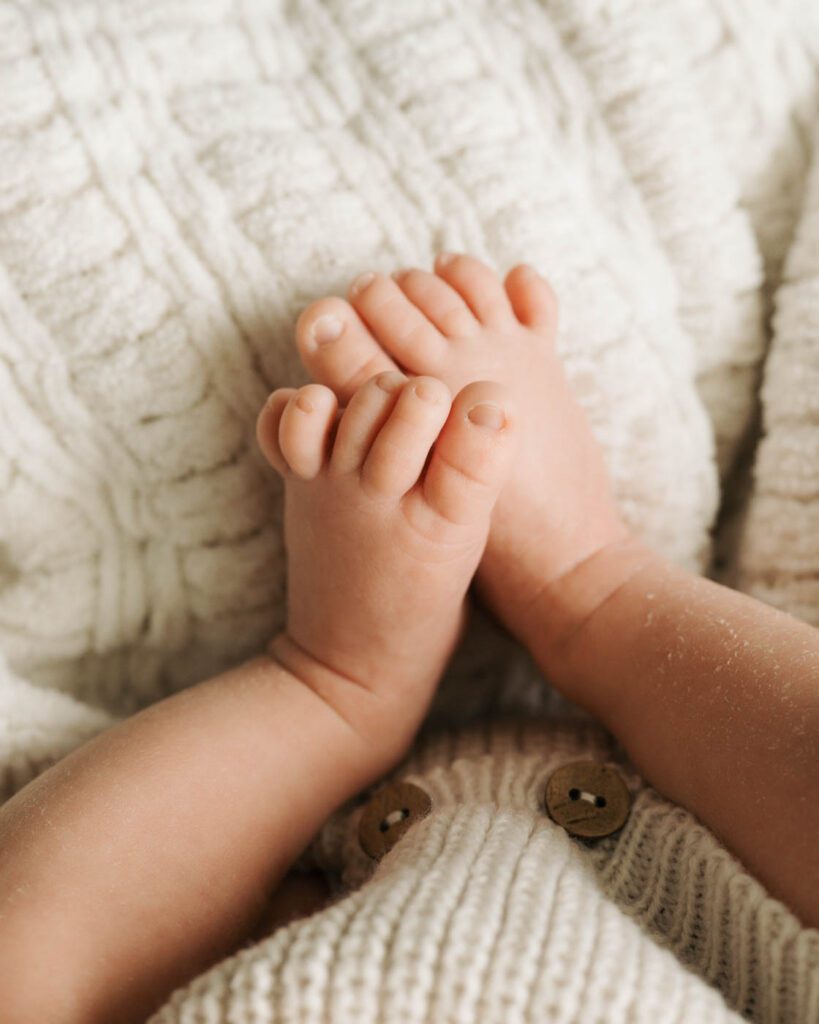 Postpartum Newborn Photography: Supporting New Parents Through A Calm, Thoughtful Experience 16 Newborn Baby Holding An Older Sibling'S Finger During A Dallas Lifestyle Newborn Photography Session.