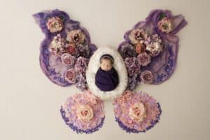 Newborn Posed On White Fur Surrounded By Floral Resembling Editing Style In Dallas Newborn Photography