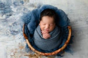 Sleeping Baby Wrapped Snuggled In A Basket For Dallas Newborn Photographer Pricing For Newborn Photography