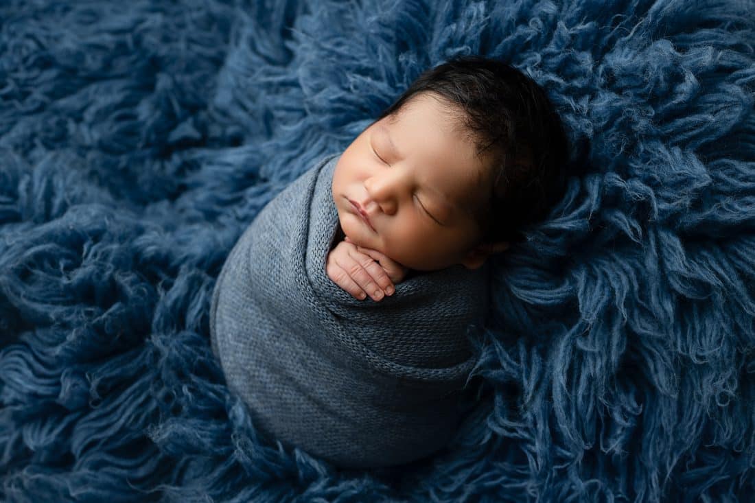 Newborn Lies On A Fluffy Blue Fur Dallas Newborn Photoshoot