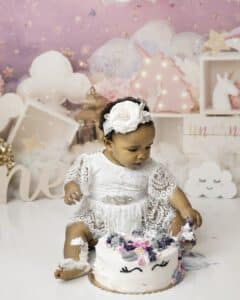 Baby Reaching For Cake Frosting During A Smash Cake Photoshoot With Cake Smash Photographer In Dallas | Lily Hayes Photography