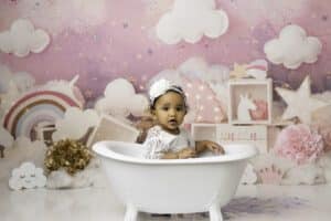 Baby Sits In A White Tub, Surrounded By Cake Smash Photography Setup With Cake Smash Photographer In Dallas | Lily Hayes Photography