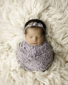 Baby Swaddled In A Purple Lace Wrap, Lying White Blanket | Photography For Newborns With Infant Photographer Lily Hayes