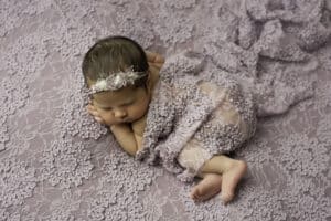 Newborn Sleeps On Her Side Wrapped On A Purple Lace Blanket Captured By Dallas Newborn Photographer | Lily Hayes Photography