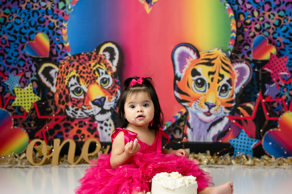 First Birthday Cake Smash Session With Colorful Rainbow Lisa Frank Inspired Backdrop And Playful Portraits