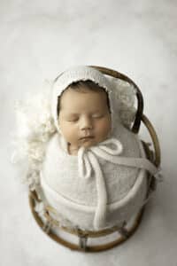 Newborn In A Wicker Chair Sleeping Posed By Dallas Baby Photographer | Lily Hayes