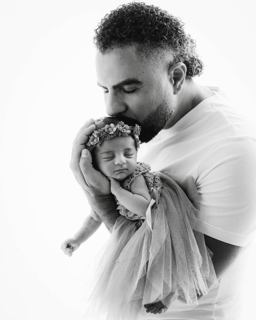 Best Lens For Newborn Photography In Dallas 12 Father Holding Newborn Baby During A Dallas Newborn Photography Session