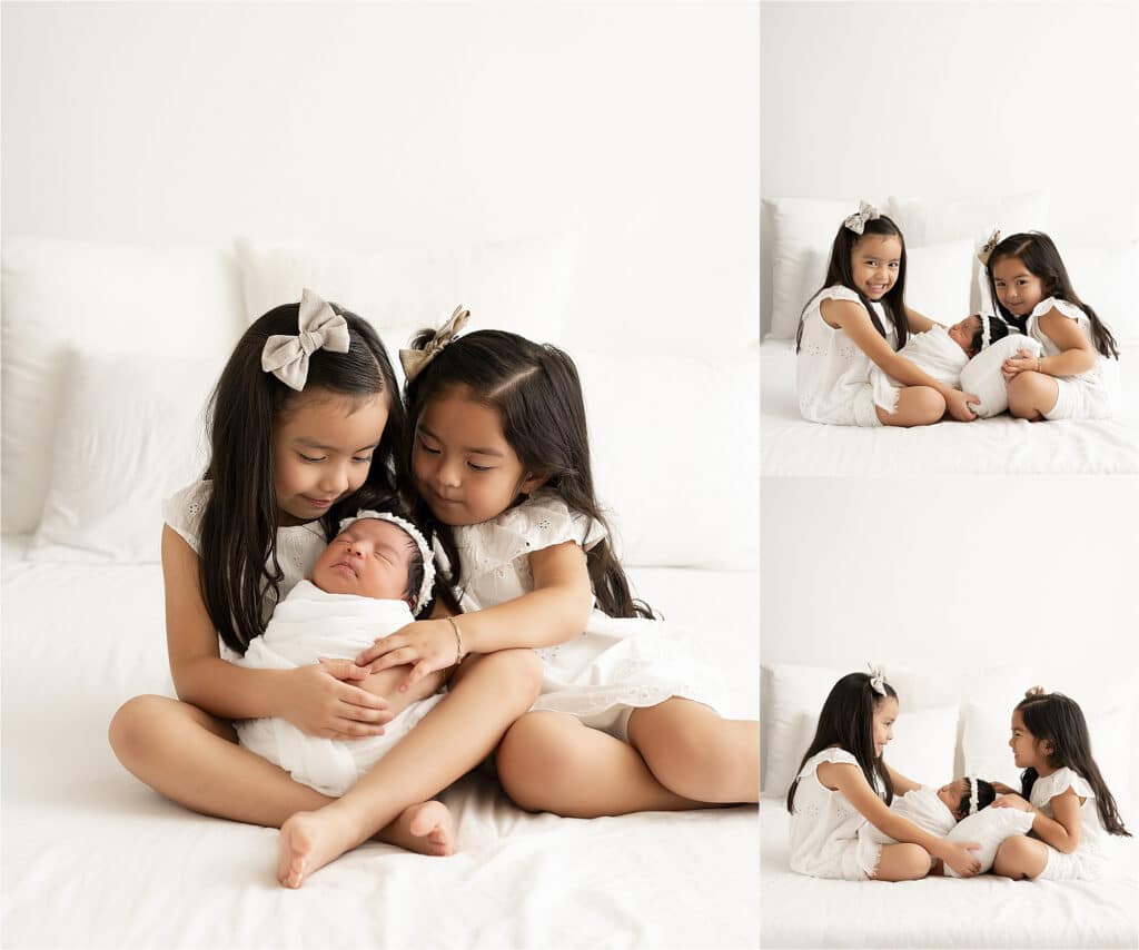 Two Young Girls In White Dresses Sit On A White Bed, Gently Holding A Swaddled Newborn. The Image Captures Multiple Views Of The Girls Cradling The Baby, Reflecting A Serene And Tender Moment Typical Of Lifestyle Newborn Pictures In Dallas, Tx.