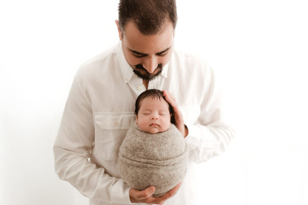 Father Holding His Newborn Baby During A Natural Lifestyle Newborn Photography Session In Dallas