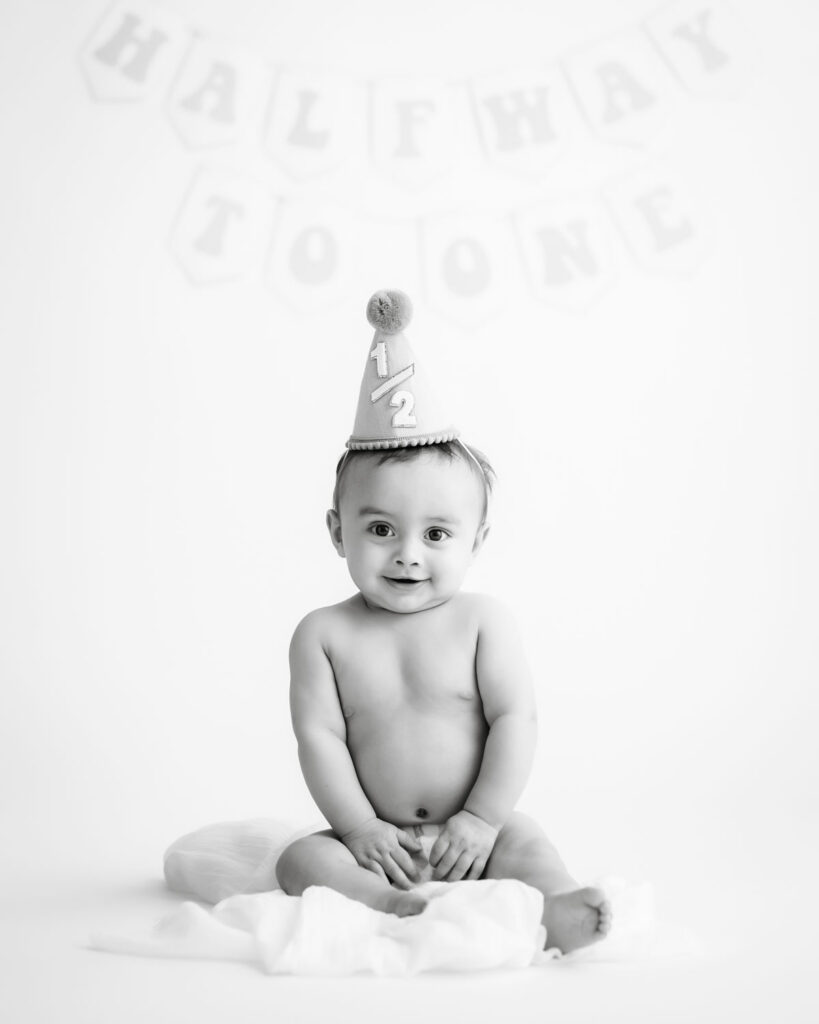 Baby Boy Wearing A Birthday Hat During A Simple Diy Cake Smash Photoshoot At Home