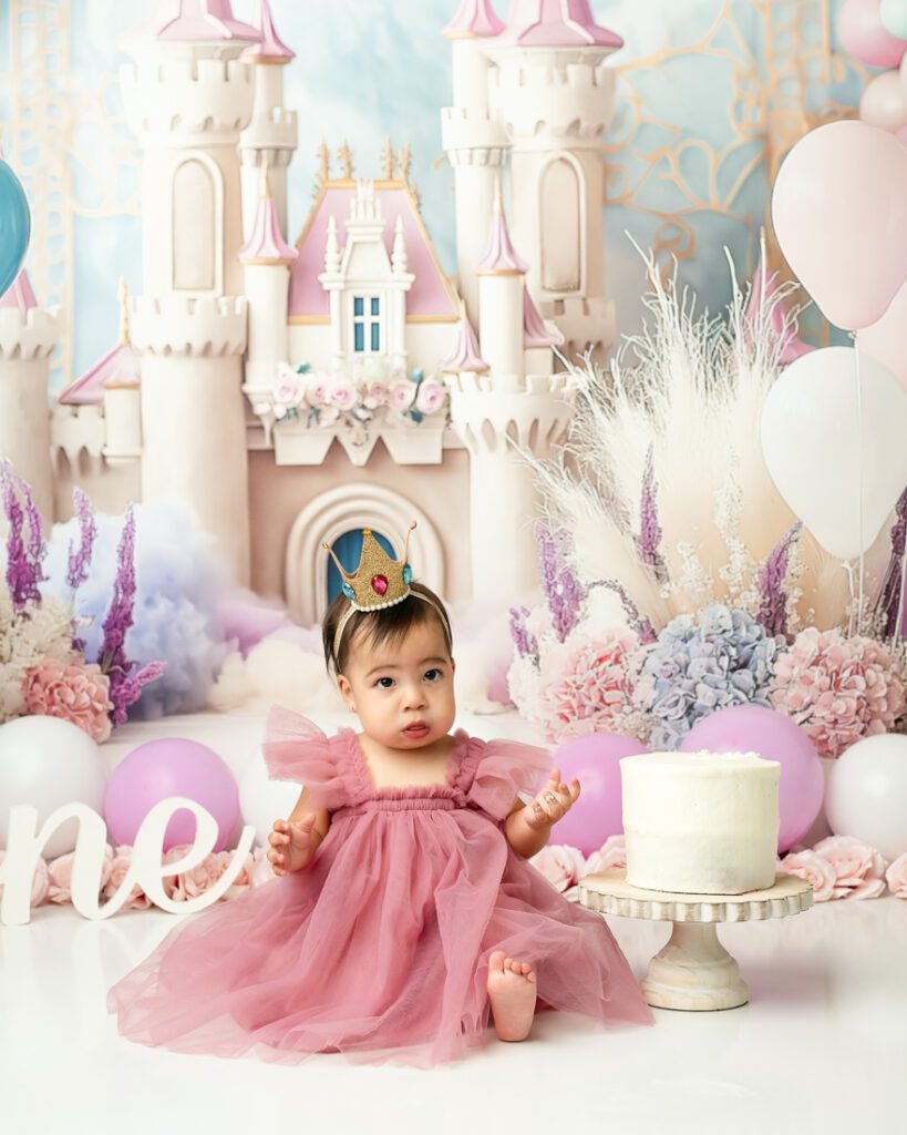 Baby Eating Cake During A Fairytale Birthday Shoot With Cake Smash Photographer
