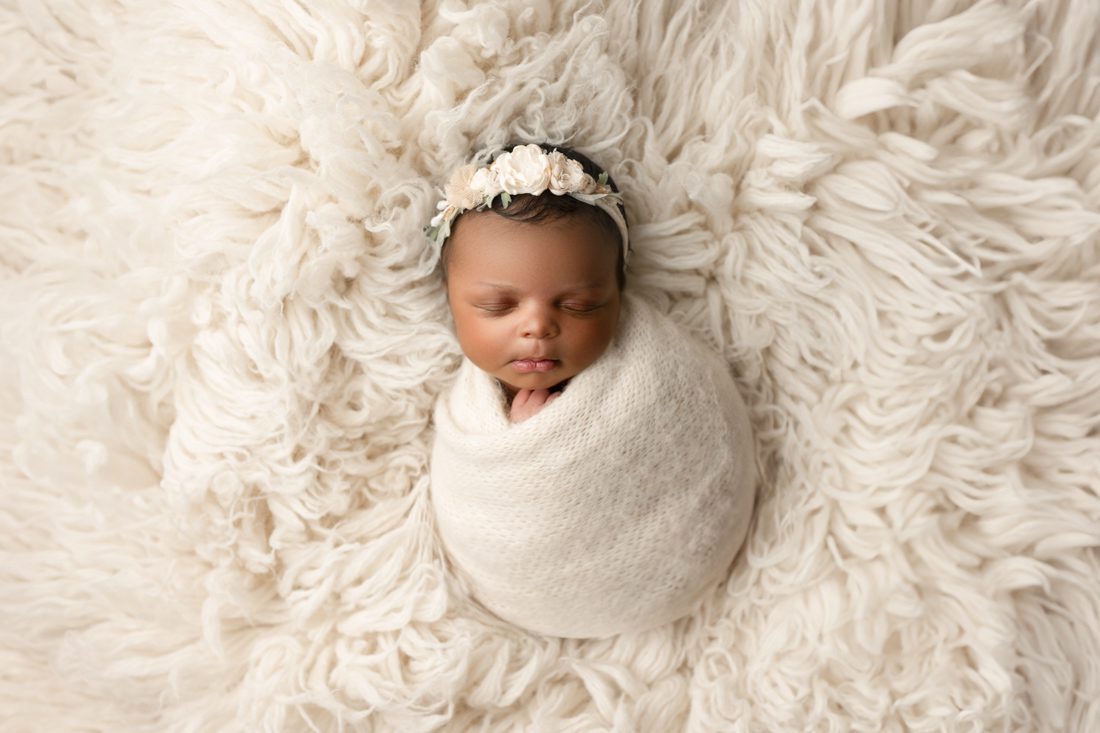 Sleeping Baby Wrapped In A Blanket, Lying On Soft Fur For Dallas Newborn Photographer