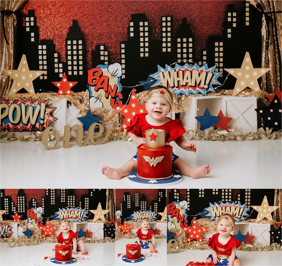 Baby Dressed As A Superhero Smiles While Seated In Front Of A Cake For Dallas Cake Smash Photographer