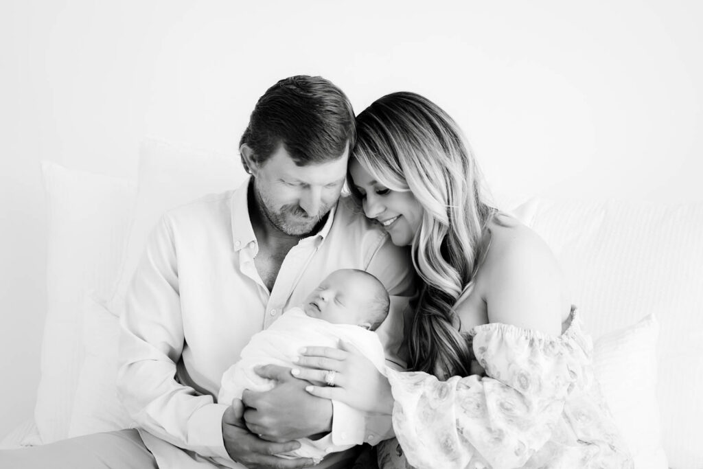 Black And White Lifestyle Newborn Family Portraits With Parents Holding Baby In Dallas Studio