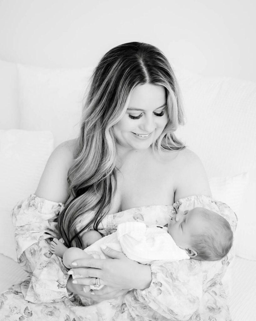 Mother Holding Newborn Baby During Lifestyle Newborn Photography Session With Soft Natural Light