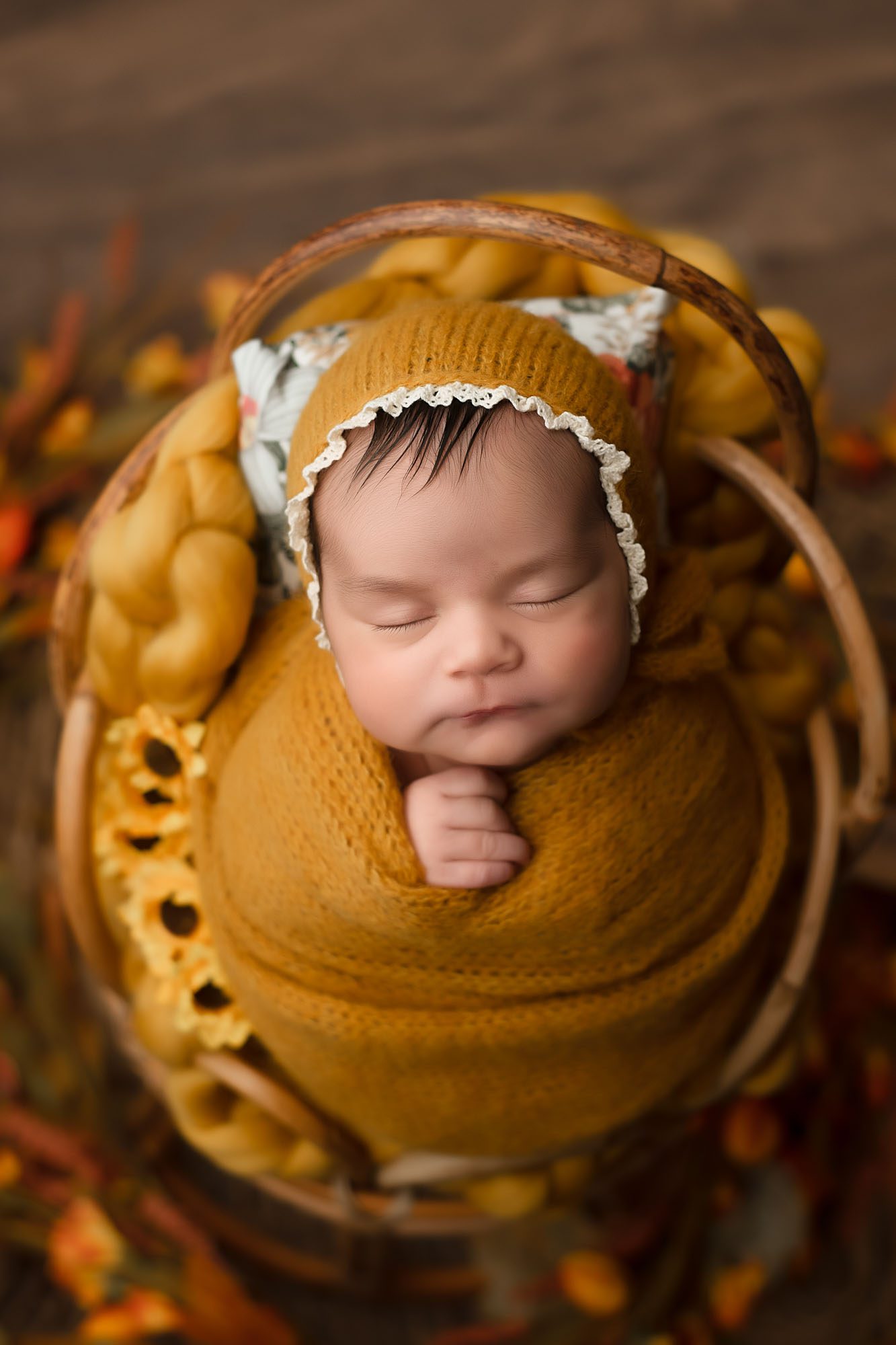 Cozy Newborn Portrait In A Rustic Basket With Yellow Tones Captured By A Dallas Baby Photographer