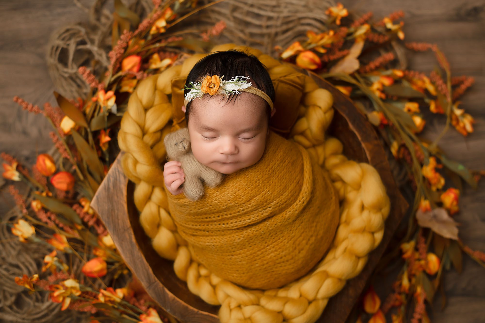 Sleeping Baby Girl In Mustard Wrap Holding A Tiny Teddy Bear With A Flower Headband – Dallas Newborn Photography Session