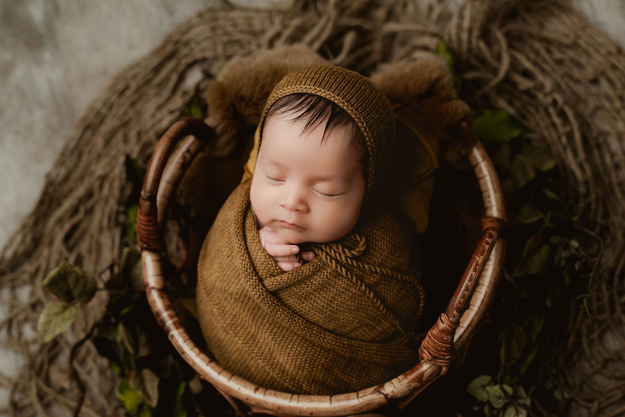 Close-Up Of A Sleeping Newborn Wrapped In Brown Knit Blanket In Basket – Professional Dallas Newborn Photographer Session