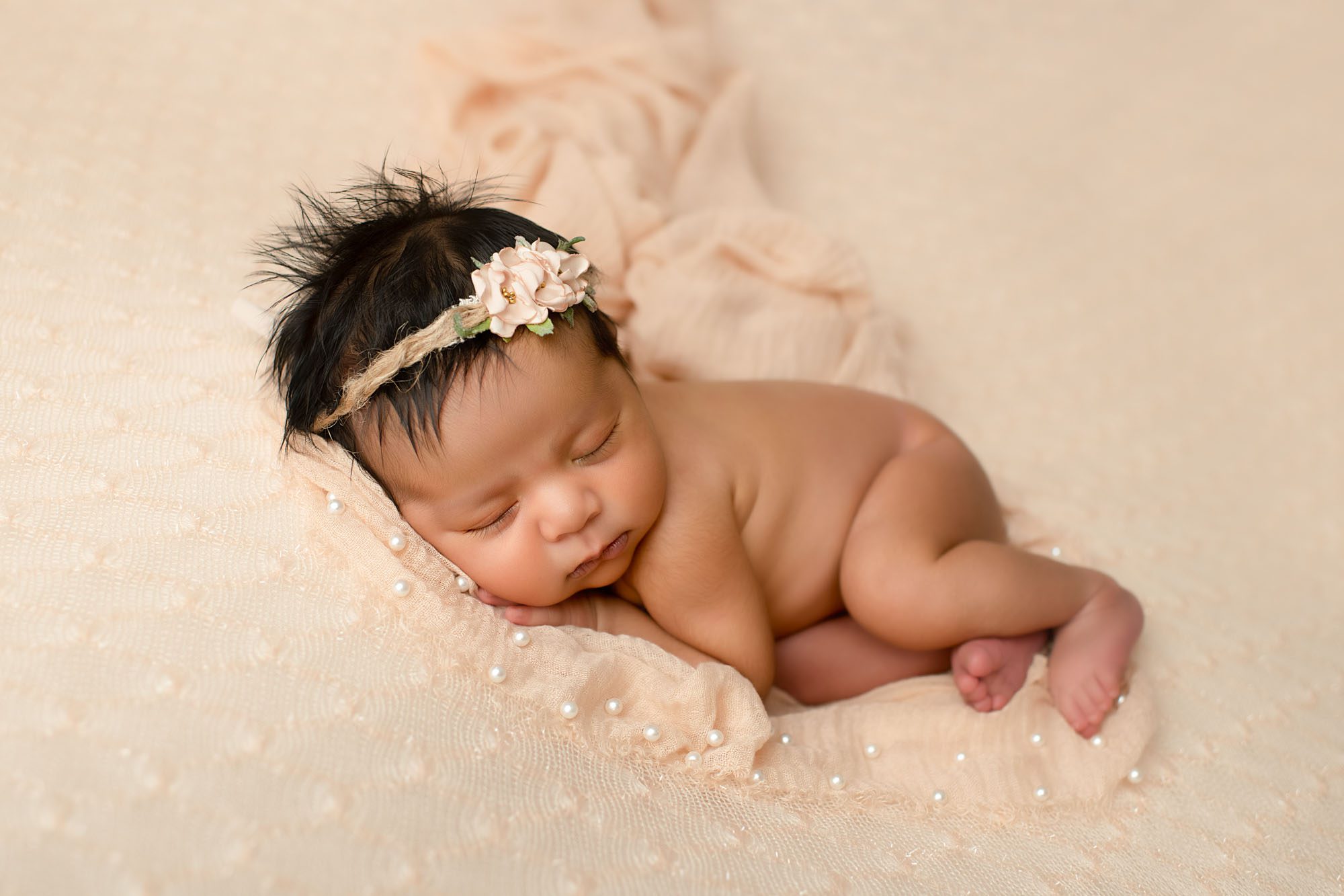 Newborn Photoshoot In Dallas Captures Baby Girl Sleeping On Pearl-Detailed Peach Blanket