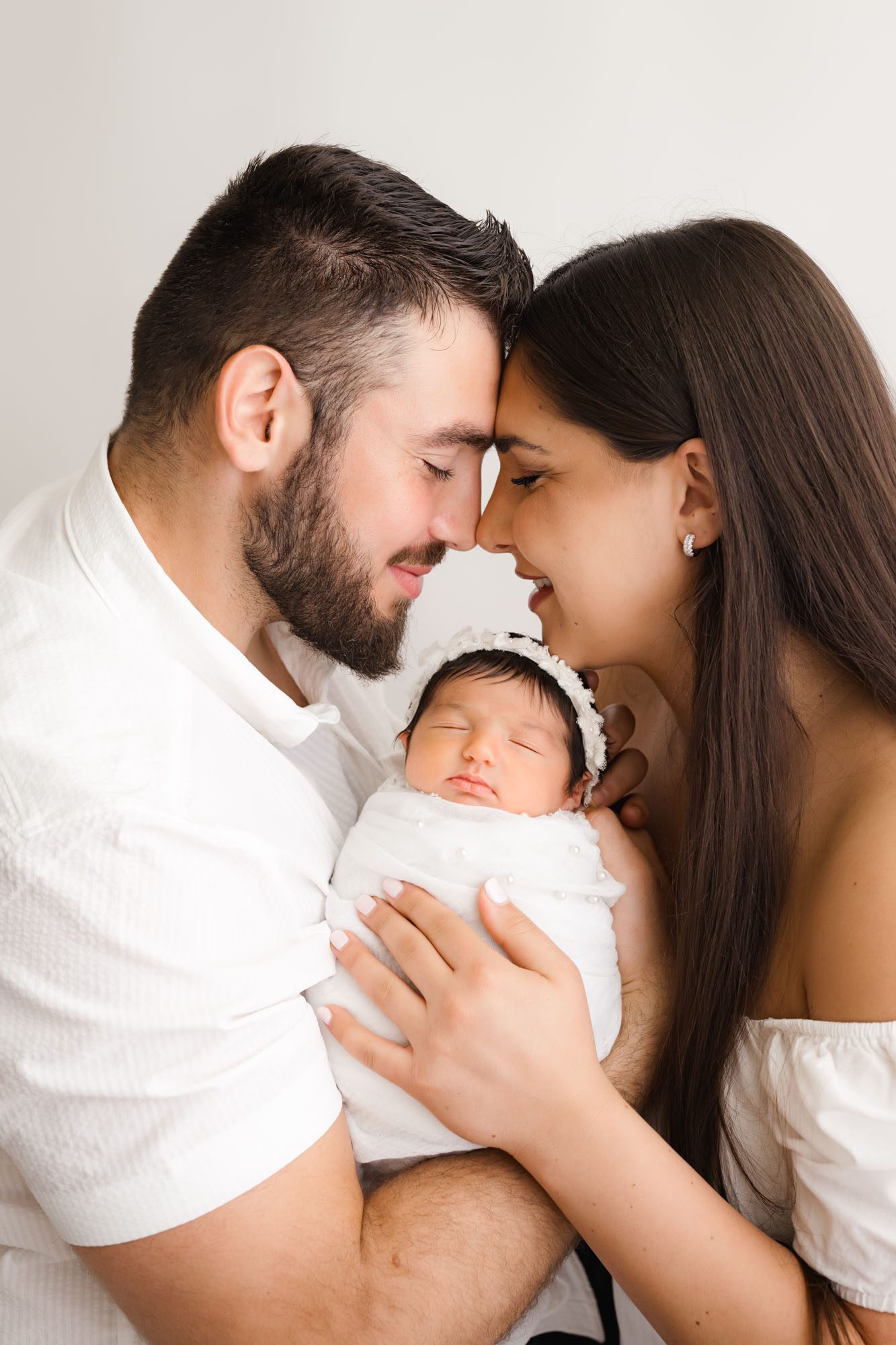 Newborn Photoshoot In Dallas With Parents Holding Baby Girl Wrapped In White