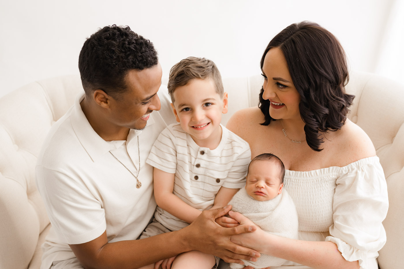 Newborn Photographer Dallas Family Session With Parents And Sibling Holding Baby In Studio