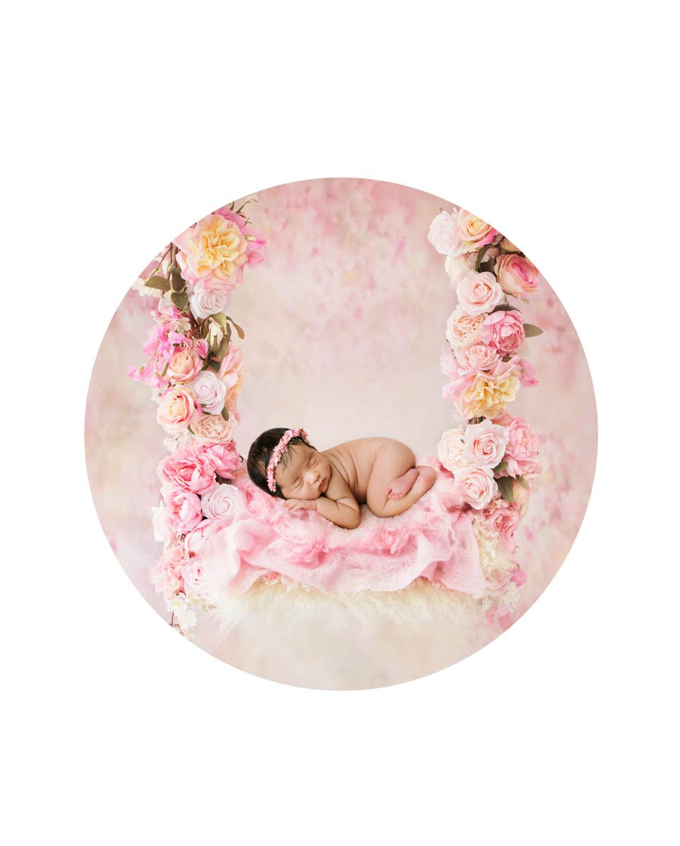 Newborn baby girl posed in a floral swing setup during a luxury studio newborn photography session in Dallas