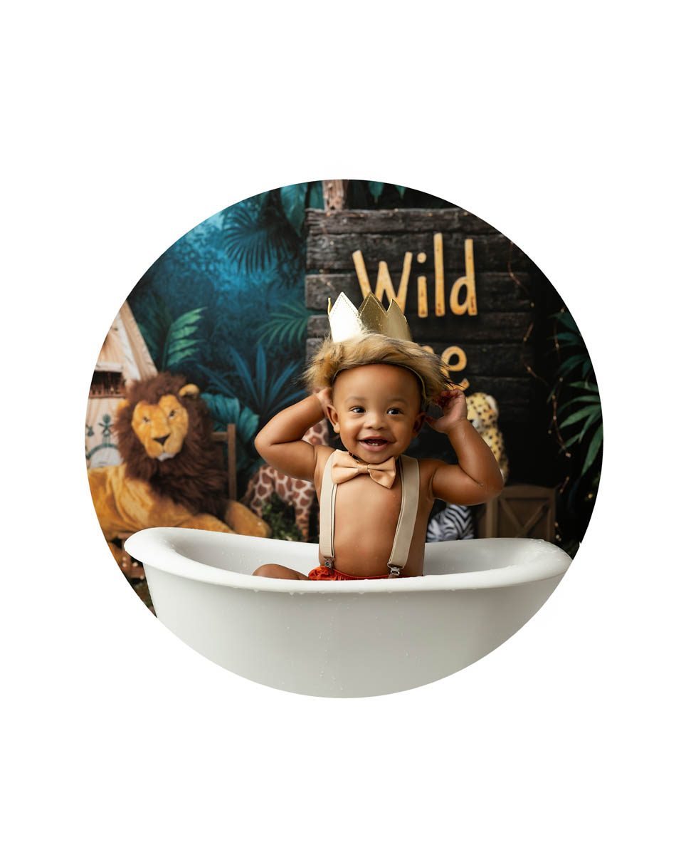 Captured by DFW cake smash photographer, Lily Hayes jungle theme baby bath session with smiling one year old