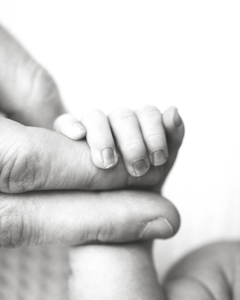 Tiny Newborn Fingers Resting On A Parent'S Hand During A Dfw Newborn Photography Session