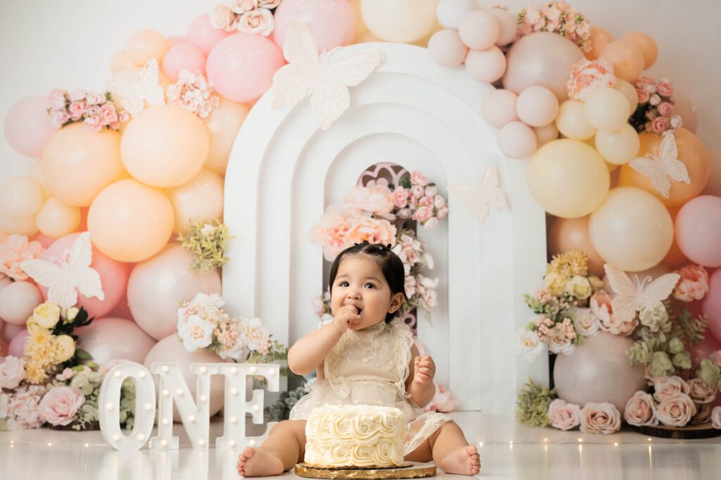 Baby Girl Enjoying Birthday Cake During Cake Smash Session In Dallas Studio