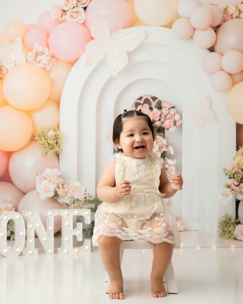 One Year Old Girl Standing During Cake Smash Session In Dallas Photography Studio