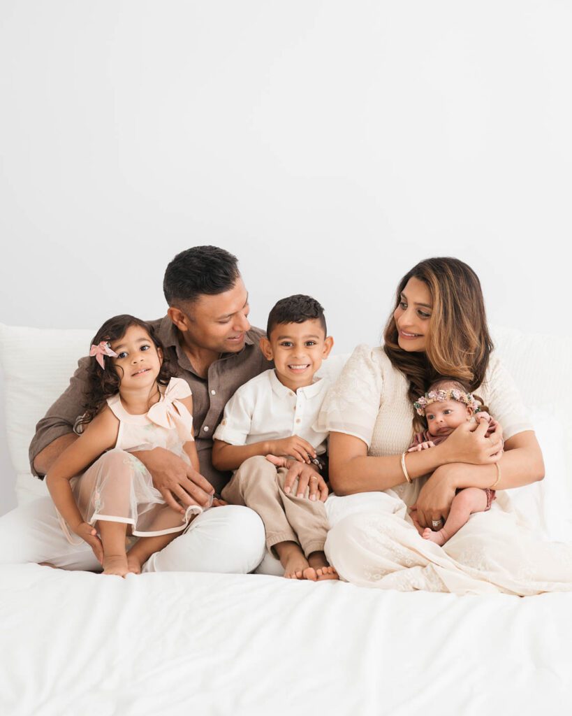 Parents Smiling With Their Children During A Dallas Newborn Photography Session.