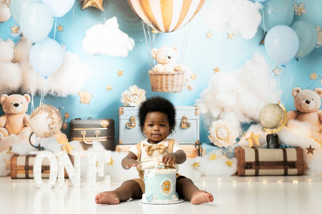 Baby Celebrating A First Birthday During A Hot Air Balloon Cake Smash Session With A Dallas Cake Smash Photographer.