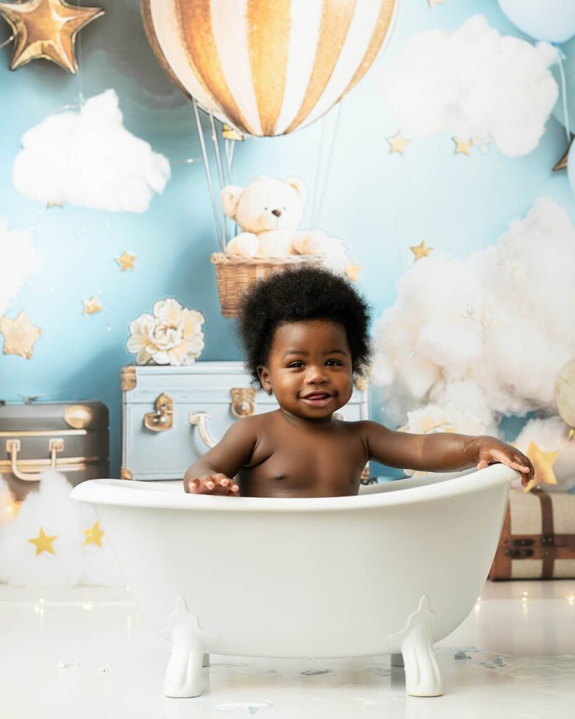 Baby Smiling In A Milk Bath After A Cake Smash Session In Dallas.