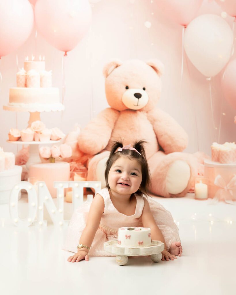 What If Your Baby Won’t Smash The Cake During A Cake Smash Session? 12 Baby Won'T Smash Cake During A First Birthday Cake Smash Session With A Dallas Photographer As She Smiles And Explores The Cake Before Taking Her First Bite.